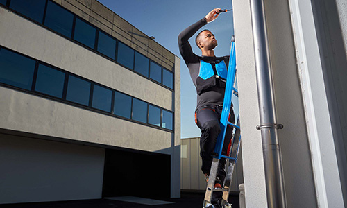 Man met WorkAir airbagvest aan het werken op ladder