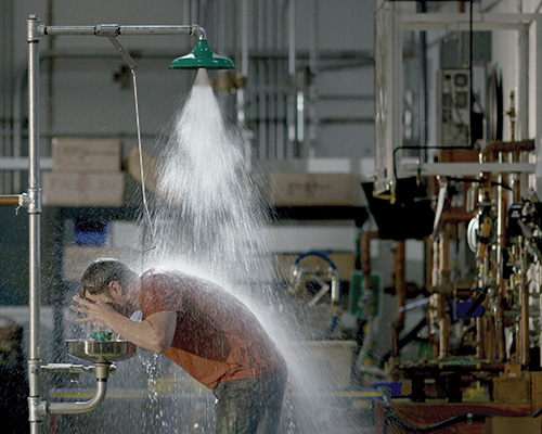 ouvrier utilisant une douche d'urgence