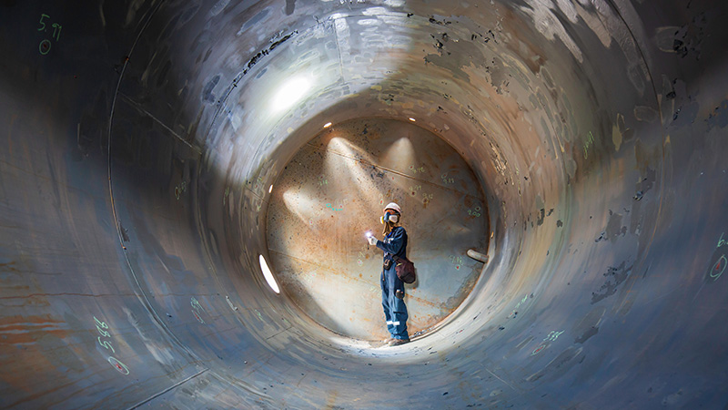 workman carrying out an inspection in a tank